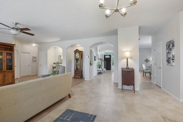 14800 Banbridge Trl, Austin, TX 78717 - living area featuring arched walkways, ceiling fan, a chandelier, and light tile patterned flooring
