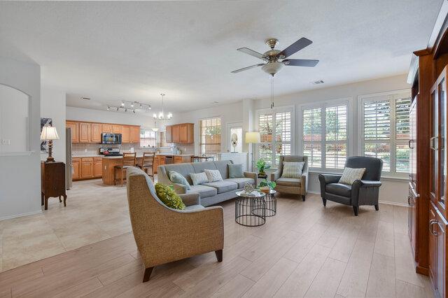 14800 Banbridge Trl, Austin, TX 78717 - living room with baseboards, a ceiling fan, light wood-style flooring, and a chandelier