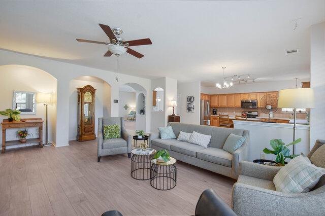 14800 Banbridge Trl, Austin, TX 78717 - living area with ceiling fan, arched walkways, light wood-style flooring, and a chandelier