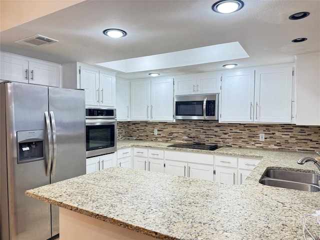 11804 Buckingham Rd, Austin, TX 78759 - kitchen with stainless steel appliances, a sink, white cabinets, light stone counters, and recessed lighting