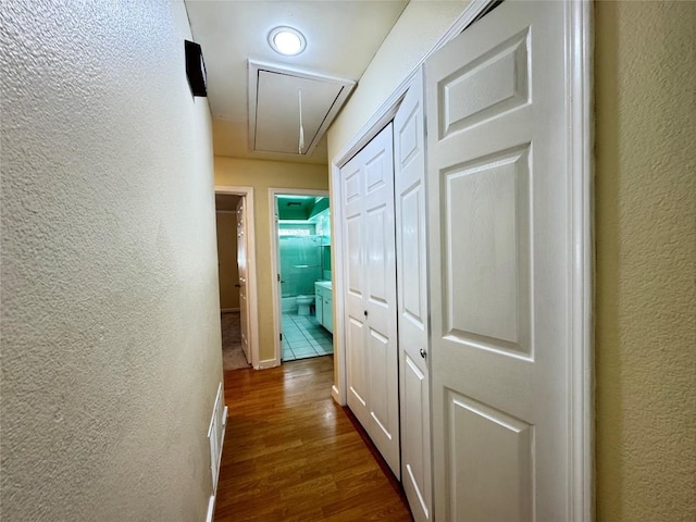 11804 Buckingham Rd, Austin, TX 78759 - corridor with attic access, a textured wall, and dark wood-style flooring