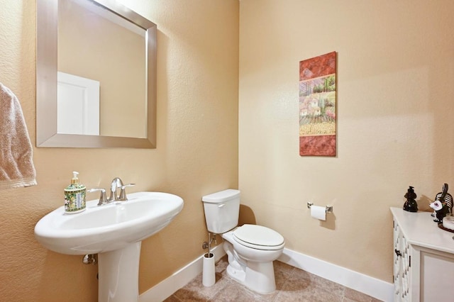 411 Torrington Dr, Austin, TX 78737 - bathroom featuring toilet, baseboards, tile patterned flooring, and a sink