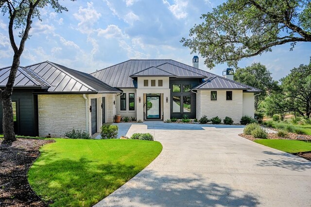 104 Megan Ln, Horseshoe Bay, TX 78657 - view of front of property featuring a standing seam roof, stone siding, metal roof, and a front yard