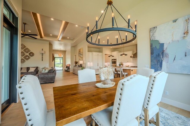 104 Megan Ln, Horseshoe Bay, TX 78657 - dining space featuring light wood-style flooring, a chandelier, beam ceiling, baseboards, and a towering ceiling