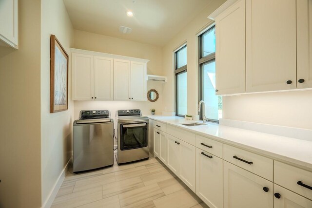 104 Megan Ln, Horseshoe Bay, TX 78657 - laundry area featuring separate washer and dryer, cabinet space, and baseboards