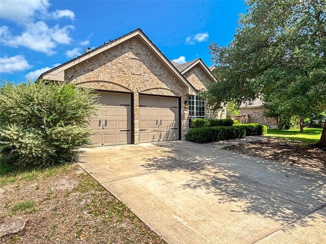 11708 Pillion Pl, Manor, TX 78653 - view of front facade featuring stone siding, a garage, and concrete driveway