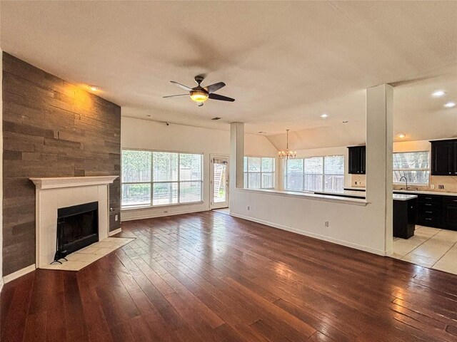 11708 Pillion Pl, Manor, TX 78653 - unfurnished living room with a chandelier, a tile fireplace, light wood-style floors, baseboards, and ceiling fan