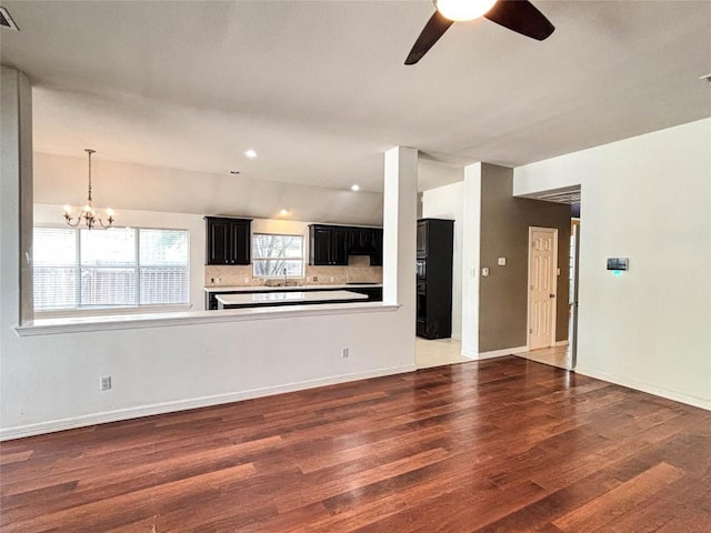 11708 Pillion Pl, Manor, TX 78653 - unfurnished living room featuring wood finished floors, ceiling fan, a chandelier, a sink, and baseboards