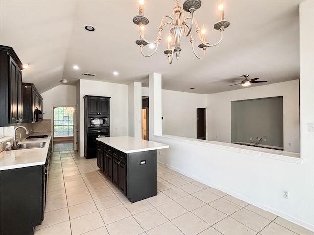 11708 Pillion Pl, Manor, TX 78653 - kitchen with a sink, dark cabinets, black appliances, light countertops, and vaulted ceiling
