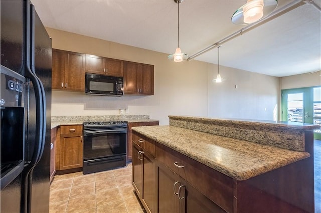 711 W 26th St Unit 703, Austin, TX 78705 - kitchen with black appliances, a center island, pendant lighting, and light stone countertops