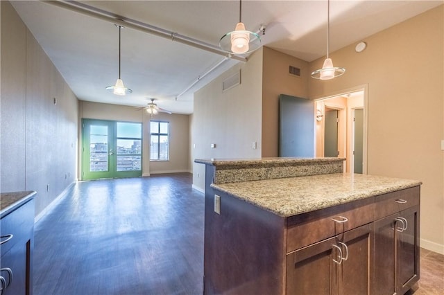 711 W 26th St Unit 703, Austin, TX 78705 - kitchen featuring baseboards, ceiling fan, wood finished floors, open floor plan, and hanging light fixtures