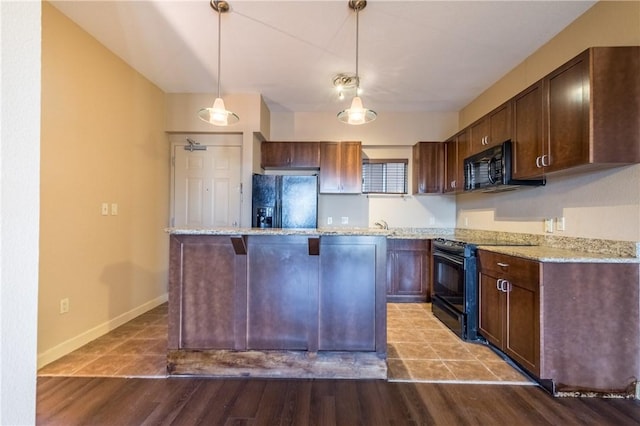 711 W 26th St Unit 703, Austin, TX 78705 - kitchen featuring black appliances, a center island, a kitchen breakfast bar, and pendant lighting