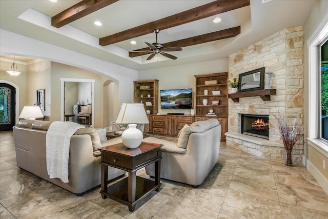 313 Aldea Cv, Georgetown, TX 78633 - living room with arched walkways, a fireplace, ceiling fan, beam ceiling, and recessed lighting