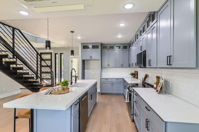 4803 Philco Dr, Austin, TX 78745 - kitchen with a sink, appliances with stainless steel finishes, light wood-type flooring, decorative backsplash, and glass insert cabinets