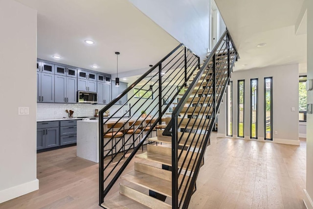 4803 Philco Dr, Austin, TX 78745 - staircase featuring baseboards, wood finished floors, and recessed lighting