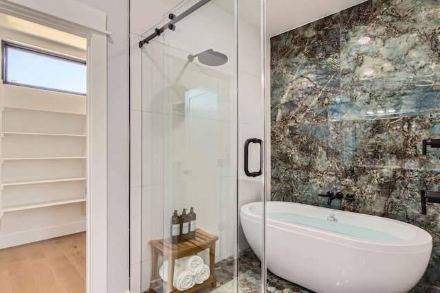 4803 Philco Dr, Austin, TX 78745 - bathroom with a freestanding bath, a shower stall, tile walls, and wood finished floors