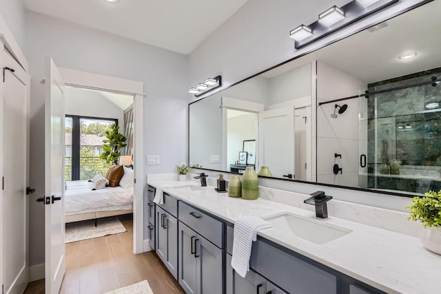 4803 Philco Dr, Austin, TX 78745 - ensuite bathroom with double vanity, a stall shower, wood finished floors, and baseboards