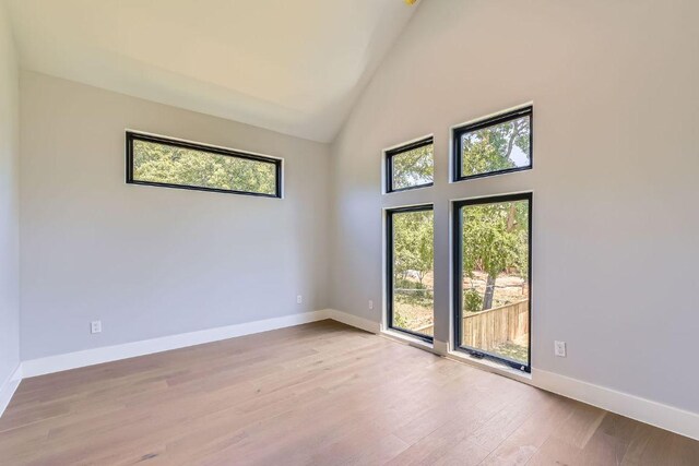 4803 Philco Dr, Austin, TX 78745 - unfurnished room with plenty of natural light, wood finished floors, high vaulted ceiling, and baseboards