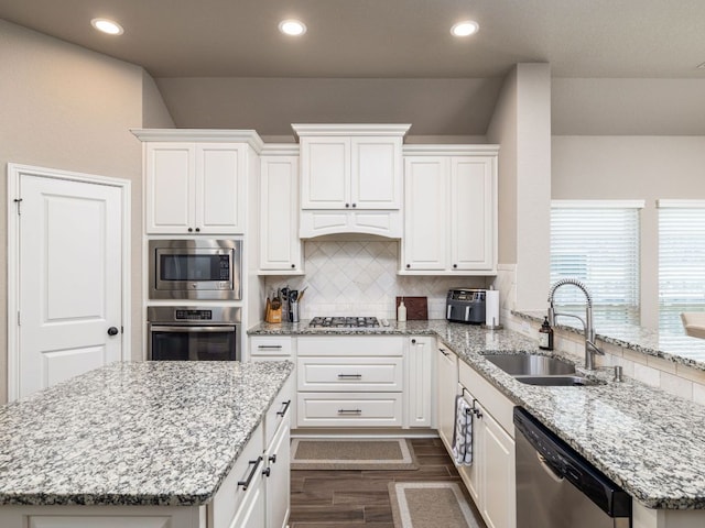 500 Cortona Ln, Georgetown, TX 78628 - kitchen featuring appliances with stainless steel finishes, a sink, white cabinetry, backsplash, and dark wood-style floors