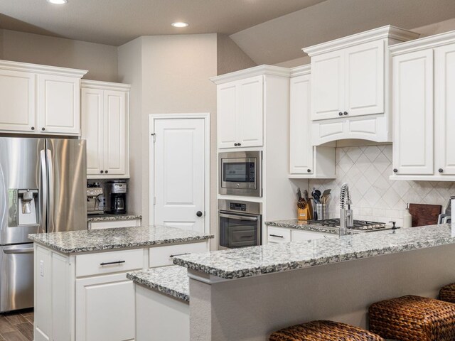 500 Cortona Ln, Georgetown, TX 78628 - kitchen featuring stainless steel appliances, white cabinets, backsplash, a peninsula, and recessed lighting