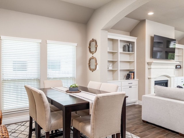 500 Cortona Ln, Georgetown, TX 78628 - dining space with dark wood-style floors, arched walkways, a fireplace, and baseboards