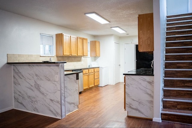 2841 San Gabriel St, Austin, TX 78705 - kitchen with washer / dryer, light wood finished floors, decorative backsplash, freestanding refrigerator, and a peninsula