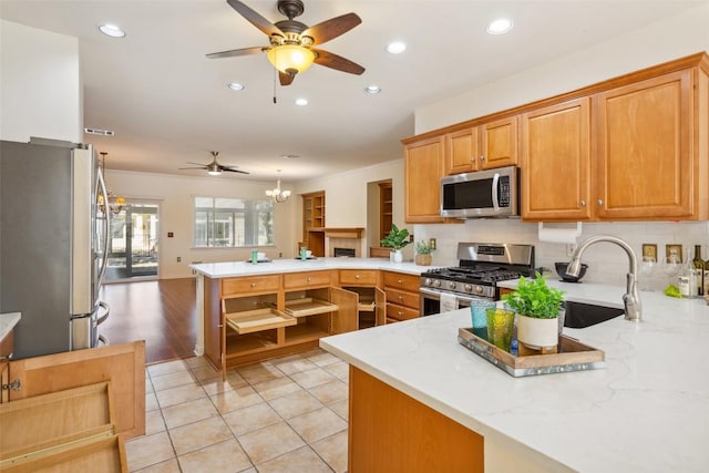 712 Texas Dr, Georgetown, TX 78633 - kitchen featuring stainless steel appliances, a peninsula, a ceiling fan, backsplash, and recessed lighting