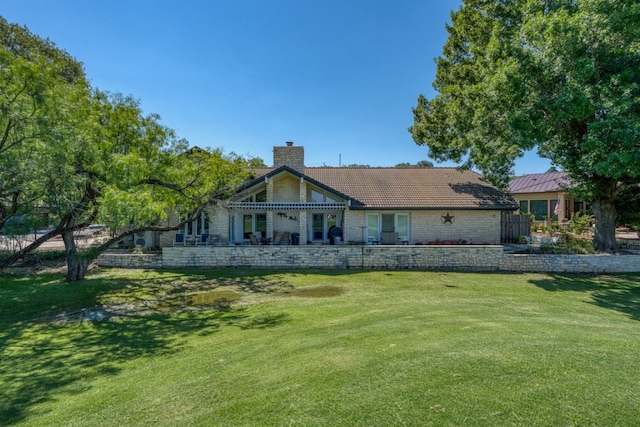 2704 Aurora, Horseshoe Bay, TX 78657 - back of property with a chimney and a lawn