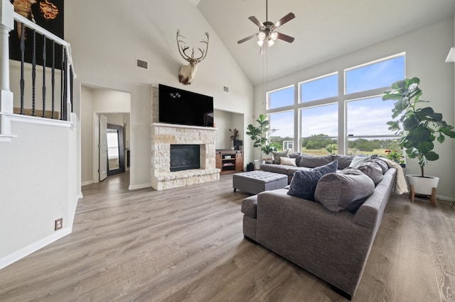1581 Grassy Field Rd, Austin, TX 78737 - living area featuring high vaulted ceiling, a stone fireplace, a ceiling fan, healthy amount of natural light, and wood finished floors