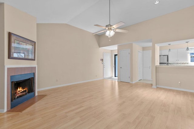 9226 Jollyville Rd Unit 191, Austin, TX 78759 - unfurnished living room featuring vaulted ceiling, light wood finished floors, ceiling fan, baseboards, and a tiled fireplace