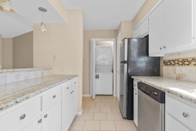 9226 Jollyville Rd Unit 191, Austin, TX 78759 - kitchen featuring stainless steel appliances, stacked washing machine and dryer, decorative backsplash, white cabinetry, and light tile patterned flooring