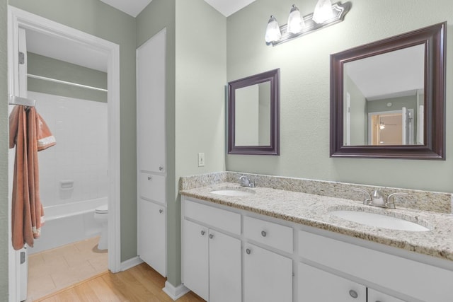 9226 Jollyville Rd Unit 191, Austin, TX 78759 - bathroom featuring double vanity, toilet, bathtub / shower combination, and wood finished floors