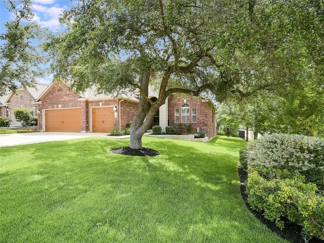 15701 Sayan Cv, Bee Cave, TX 78738 - view of front of house with brick siding, a front yard, an attached garage, and concrete driveway