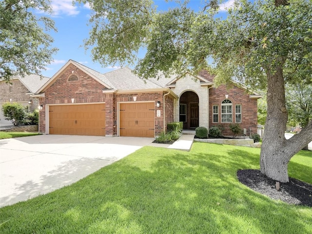 15701 Sayan Cv, Bee Cave, TX 78738 - traditional-style home with a garage, a front lawn, concrete driveway, brick siding, and a shingled roof