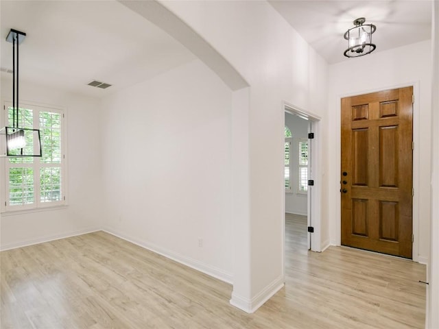 15701 Sayan Cv, Bee Cave, TX 78738 - entrance foyer with arched walkways, light wood-style flooring, and baseboards