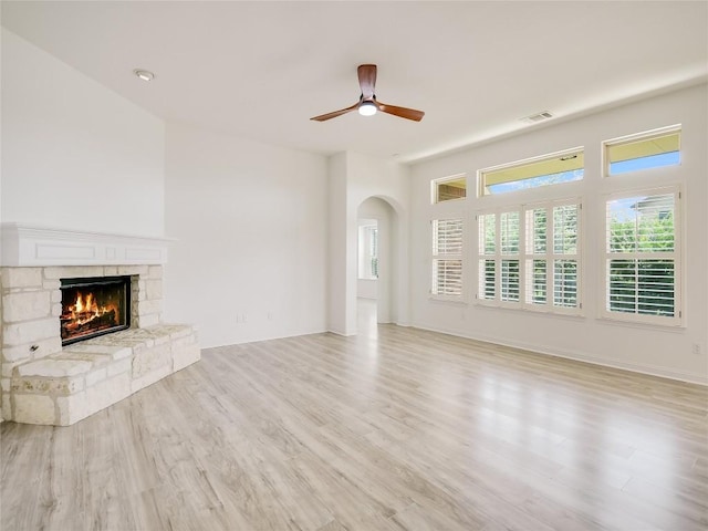 15701 Sayan Cv, Bee Cave, TX 78738 - unfurnished living room with light wood-type flooring, a fireplace, and a ceiling fan
