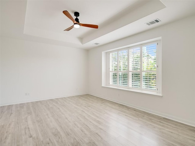 15701 Sayan Cv, Bee Cave, TX 78738 - unfurnished room featuring a raised ceiling, wood finished floors, a ceiling fan, and baseboards