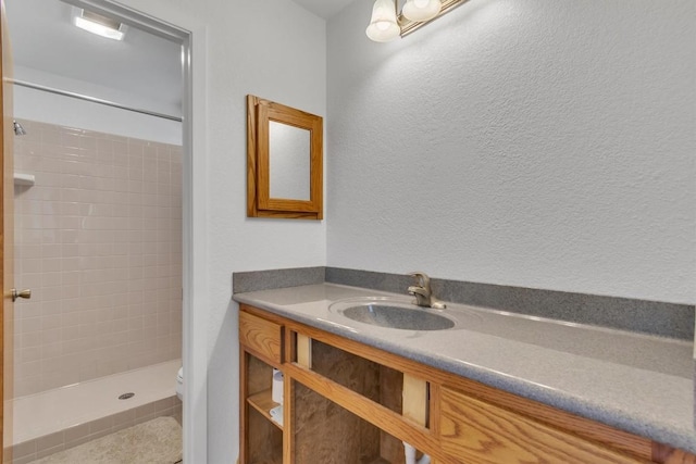 226 Mesa Rdg, Leander, TX 78641 - full bath featuring a tile shower, vanity, toilet, and a textured wall