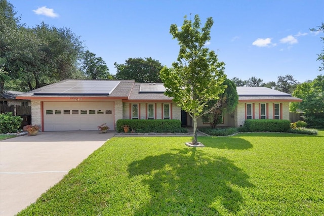 13215 Woodthorpe St, Austin, TX 78729 - ranch-style house featuring an attached garage, roof mounted solar panels, a front yard, concrete driveway, and brick siding