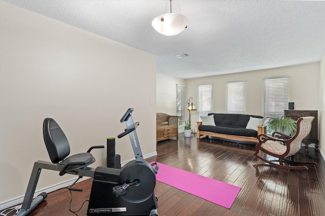 13215 Woodthorpe St, Austin, TX 78729 - workout area featuring a textured ceiling, baseboards, and hardwood / wood-style flooring