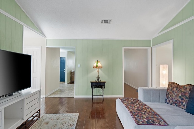 13215 Woodthorpe St, Austin, TX 78729 - living area featuring vaulted ceiling, hardwood / wood-style floors, baseboards, and wooden walls