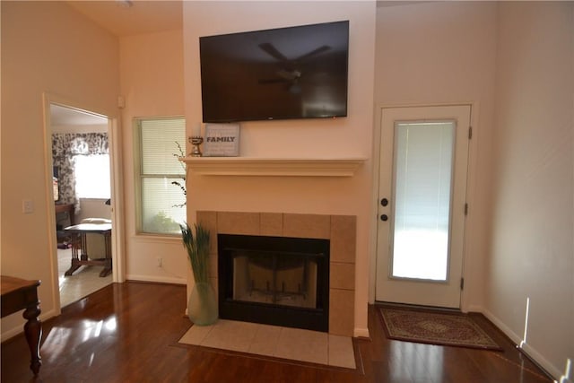 241 Wild Buffalo Dr, Kyle, TX 78640 - unfurnished living room featuring wood finished floors, a tile fireplace, and healthy amount of natural light
