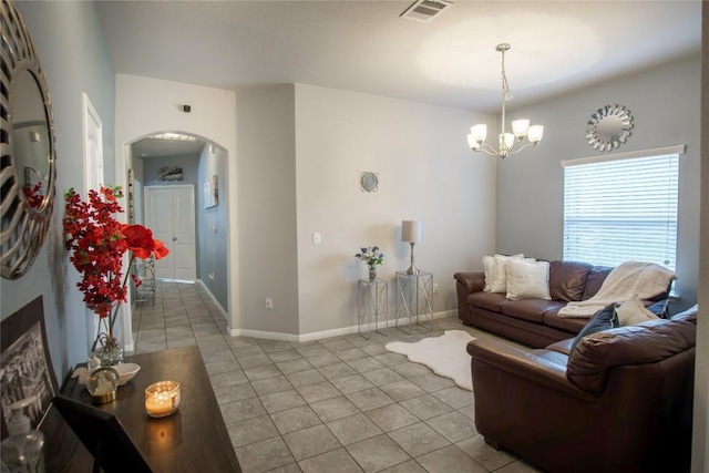19108 Obed River Dr, Pflugerville, TX 78660 - living room with arched walkways, light tile patterned floors, a chandelier, and baseboards