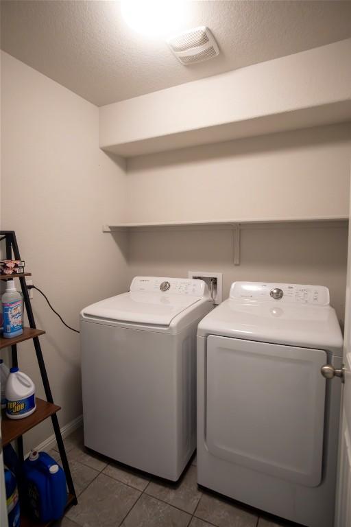 19108 Obed River Dr, Pflugerville, TX 78660 - laundry room with separate washer and dryer, a textured ceiling, tile patterned floors, and baseboards