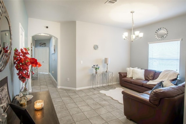 19108 Obed River Dr, Pflugerville, TX 78660 - living room featuring arched walkways, light tile patterned floors, and a chandelier