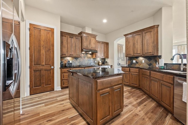416 Marina Village Cv Unit 416, Austin, TX 78734 - kitchen featuring a sink, stainless steel appliances, under cabinet range hood, light wood finished floors, and a center island