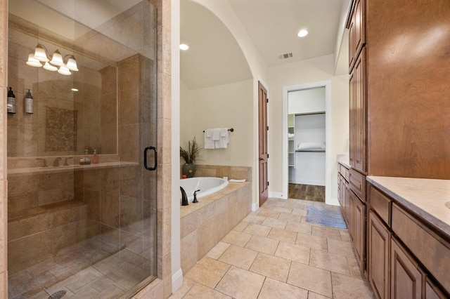 416 Marina Village Cv Unit 416, Austin, TX 78734 - bathroom with vanity, a shower stall, a bath, a walk in closet, and recessed lighting