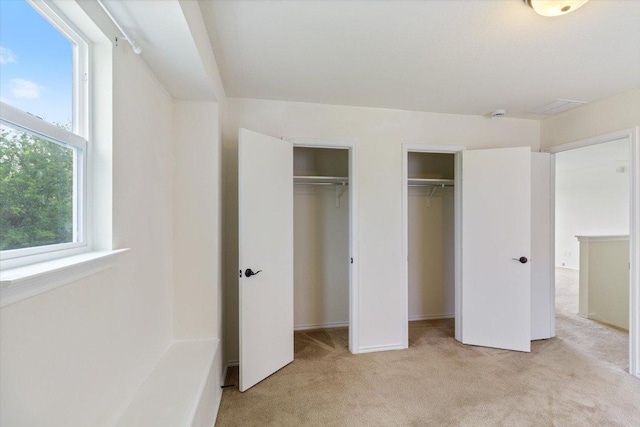 6729 Sunderland Trl, Austin, TX 78747 - unfurnished bedroom featuring light colored carpet, multiple closets, and multiple windows