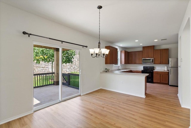 6729 Sunderland Trl, Austin, TX 78747 - kitchen with appliances with stainless steel finishes, light wood finished floors, a chandelier, light countertops, and baseboards