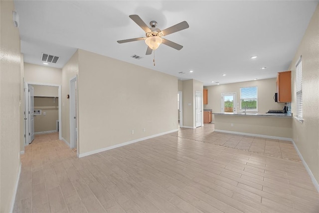 14125 Fallsprings Way, Manor, TX 78653 - unfurnished living room featuring light wood-type flooring, a ceiling fan, and recessed lighting